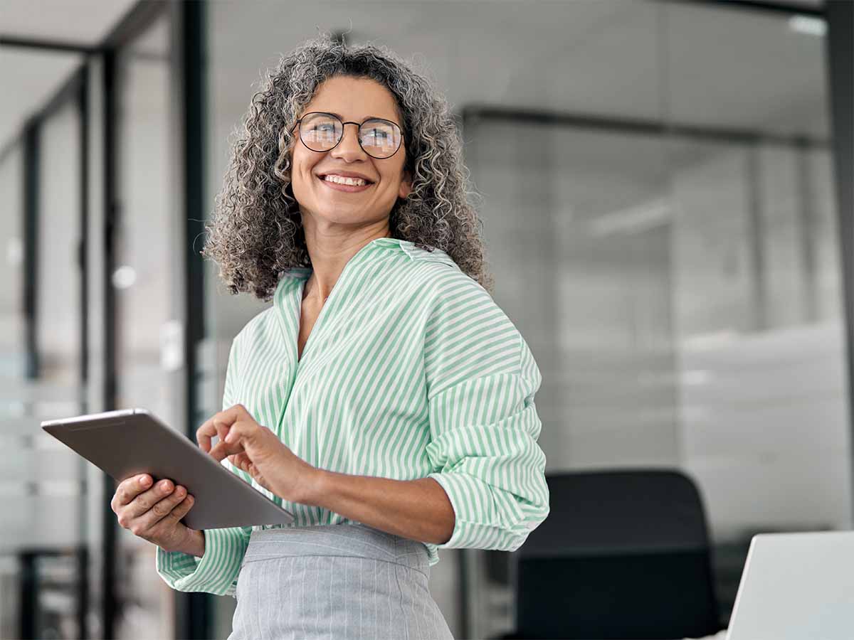 Executive holding tablet and smiling