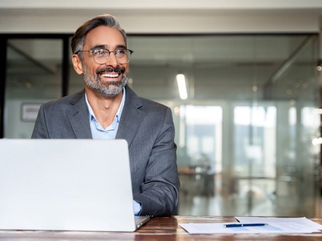 Senior professional using laptop in an office