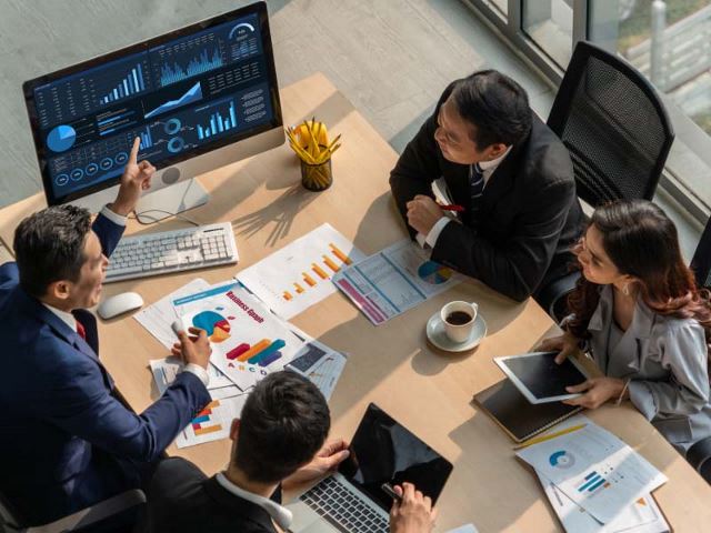 Group of colleagues reviewing a software dashboard