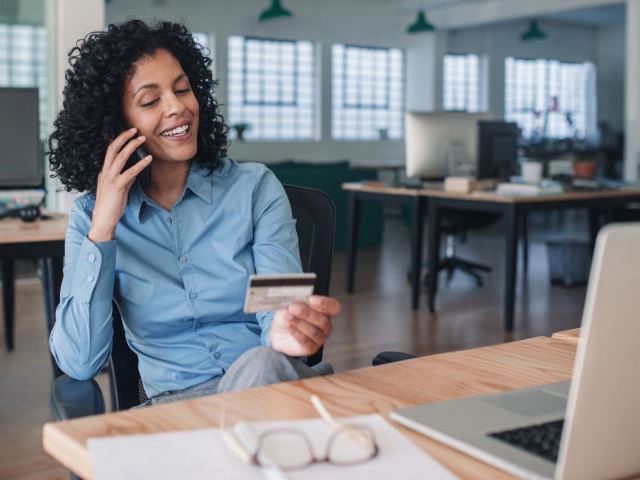 Professional reading a credit card number over the phone in an office