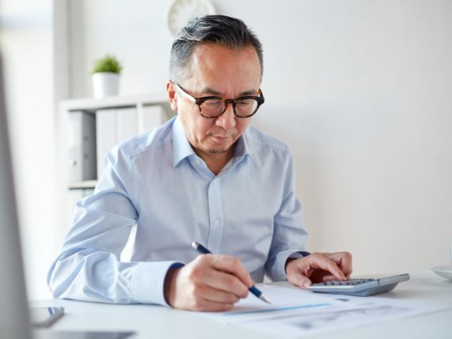 Senior professional man using a calculator