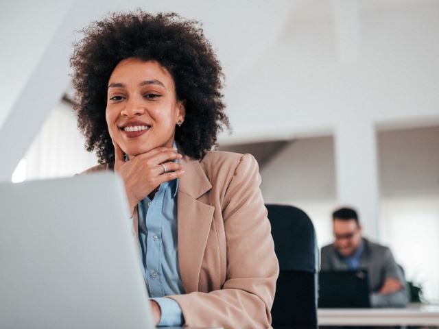 Professional woman looking at laptop and smiling