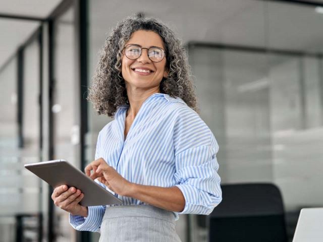 Confident senior woman using a tablet in an office