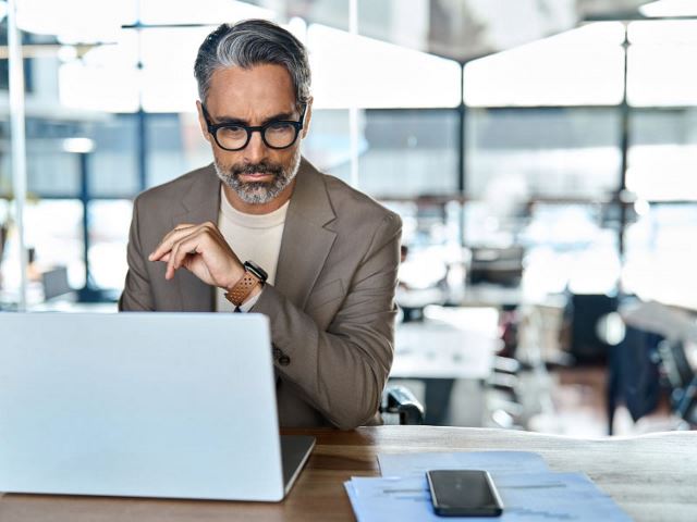 Senior executive looking at his laptop