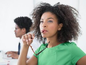 Professionele vrouw die haar bril vasthoudt en denkt