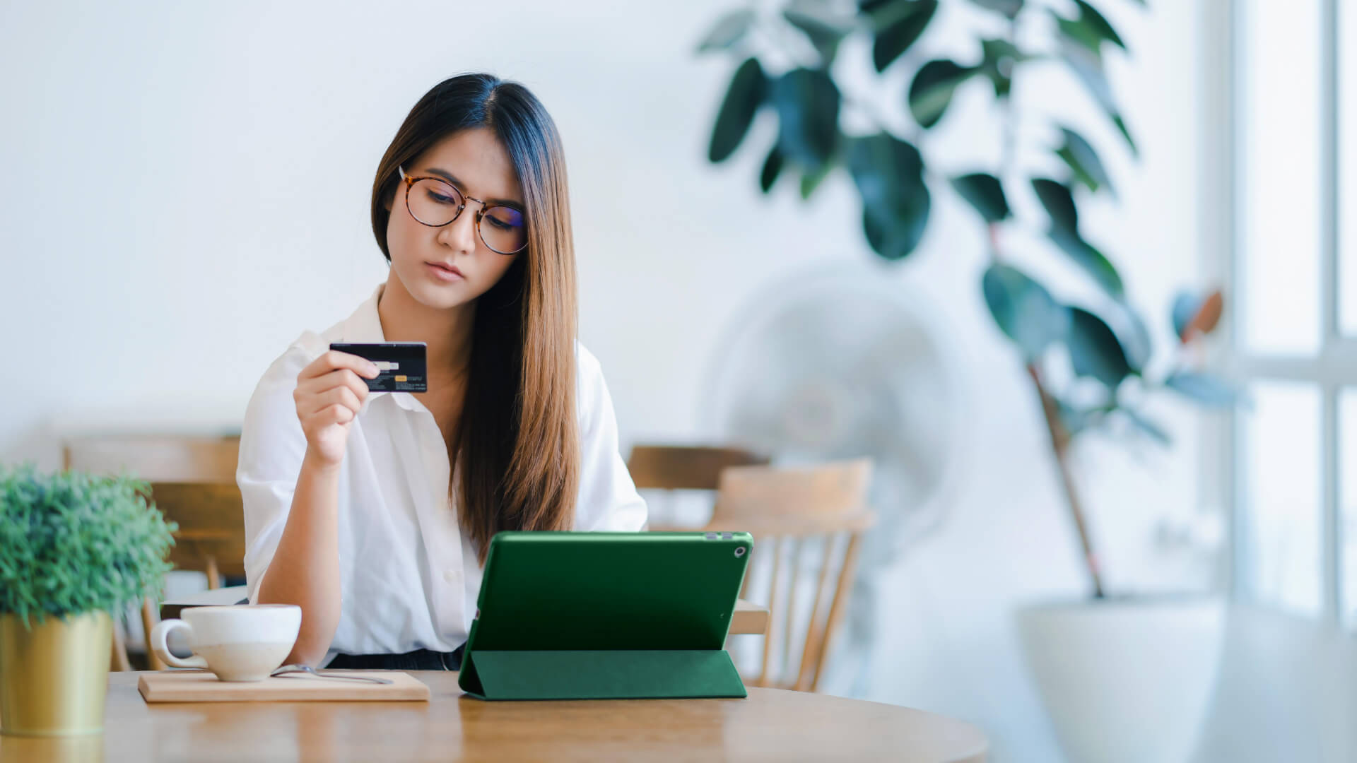 eCommerce customer on tablet looking at credit card