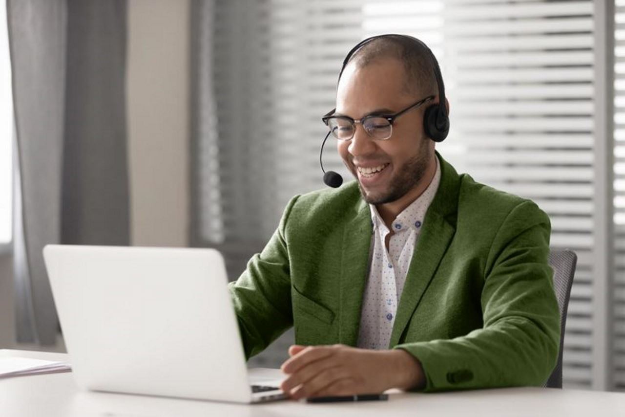 Elegant gekleideter Mann telefoniert am Laptop im Büro