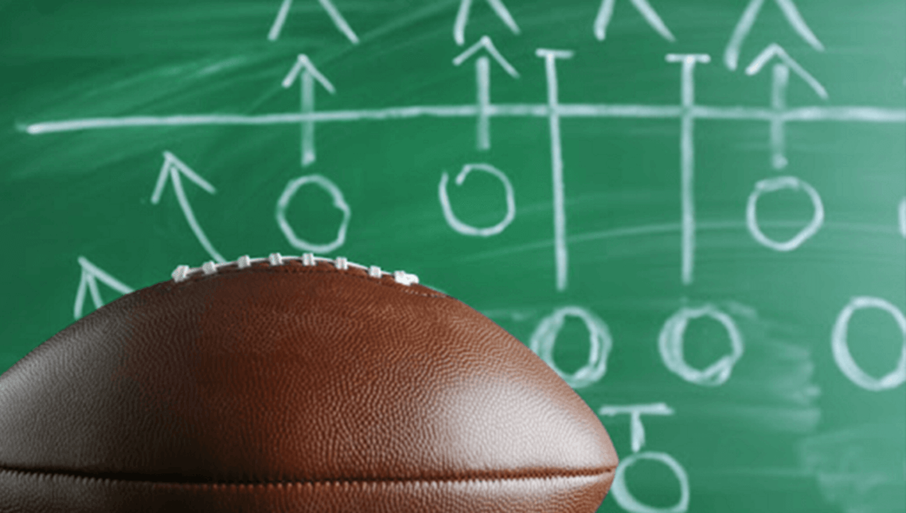 Football in front of a chalkboard with team movement drawings