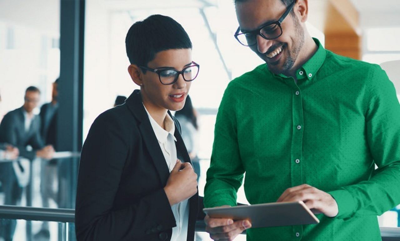 man and woman in an office looking at a tablet