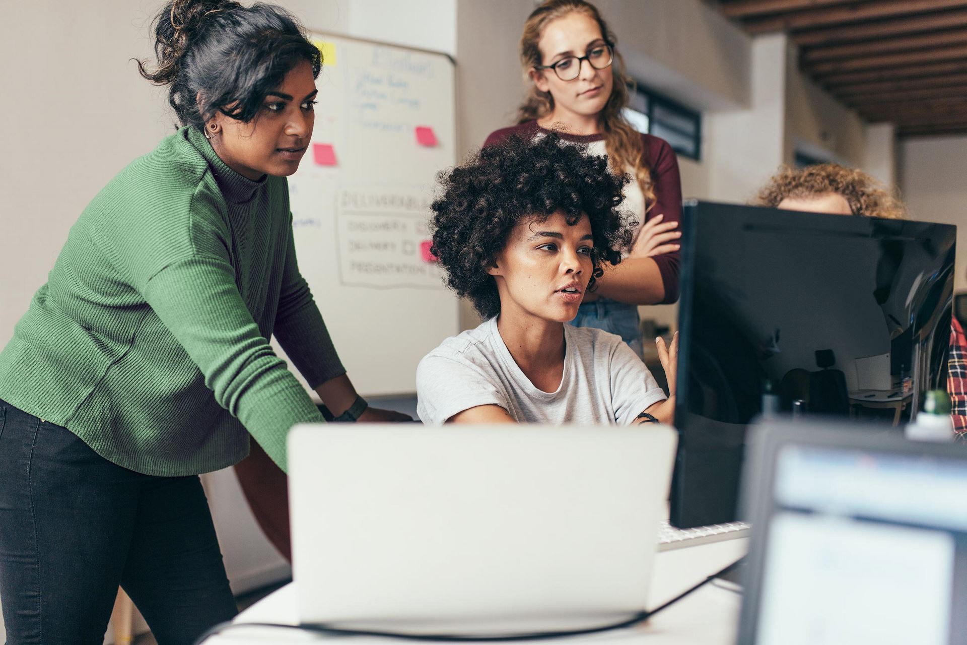 Female business team working together looking at a laptop screen