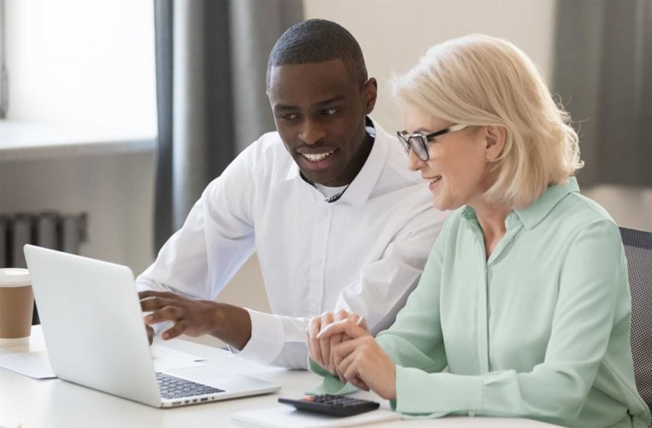 man and woman looking at a laptop in an office