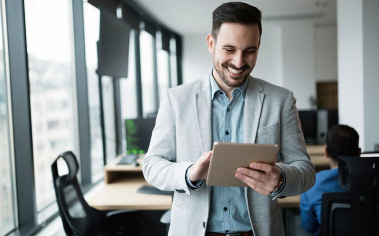 Man reading top 5 benefits of accounts receivable automation on tablet in building