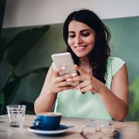 Vrouw kijkt naar telefoon in café