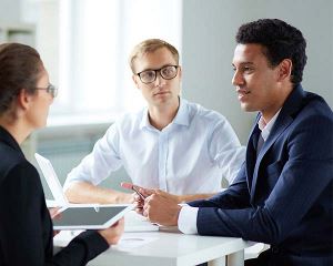 Drie professionals in gesprek rond een tafel