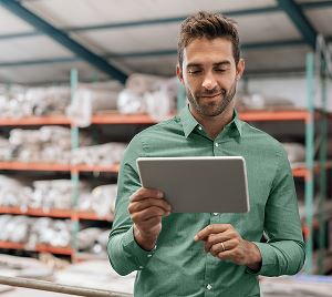 Mann in einem Lager mit Tablet