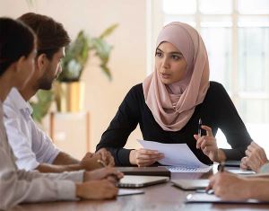Frau, die Hijab trägt, leitet eine Teambesprechung