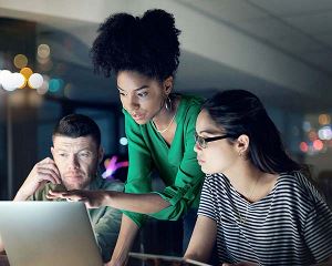 Groep collega's die samenwerken op een computer