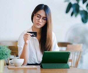 Woman paying with credit card on tablet